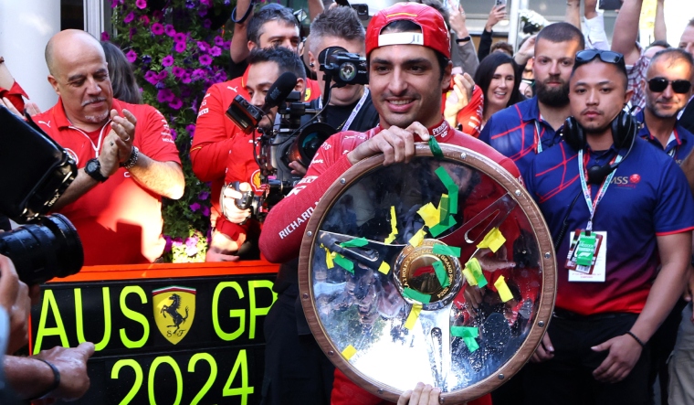 Ferrari's Carlos Sainz Jr. celebrates with the trophy after winning the Australian Grand Prix | Reuters